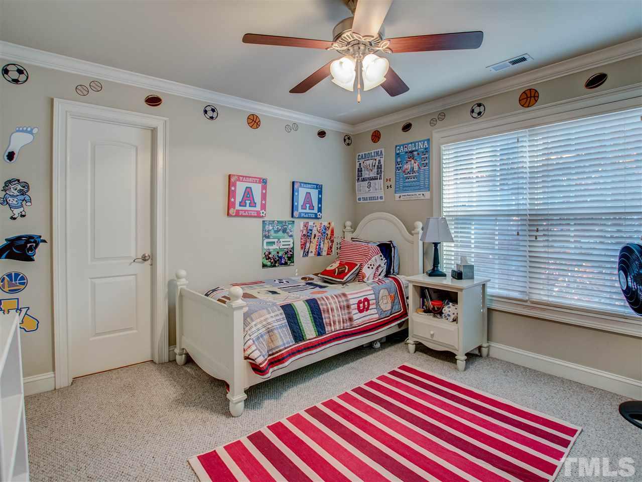 4307 Oakthorne Way Raleigh, NC 27613 - Photo 24 of 30 a bedroom with a bed and a chandelier