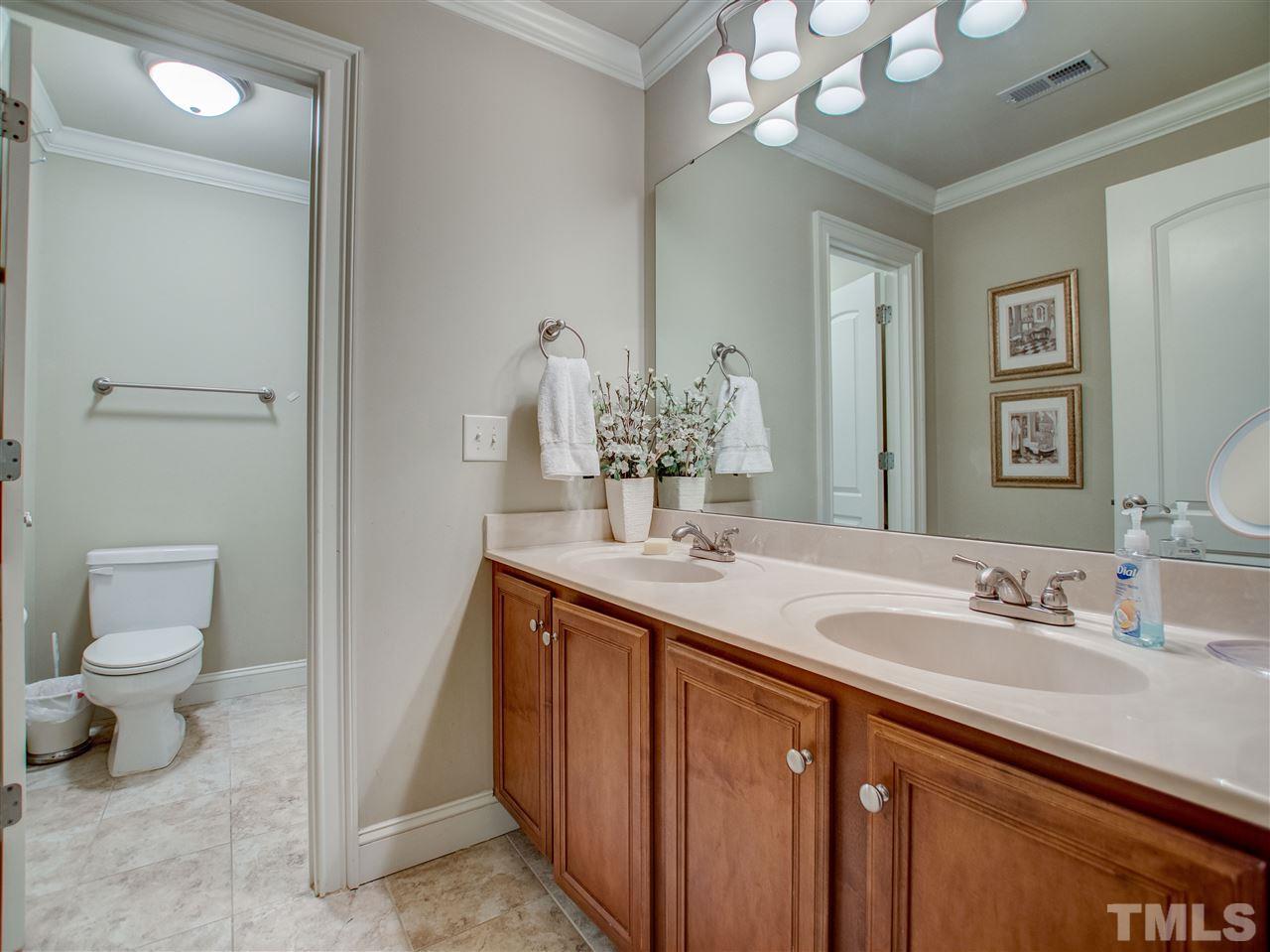 4307 Oakthorne Way Raleigh, NC 27613 - Photo 25 of 30 a bathroom with a double vanity sink and a toilet