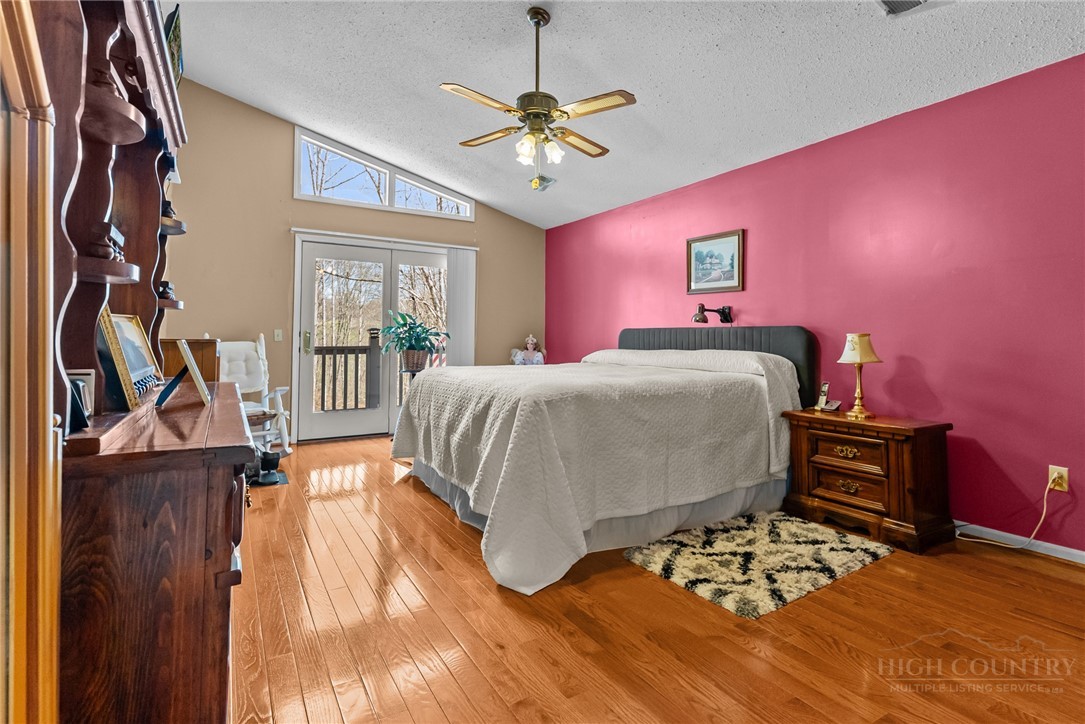 271 Quail Hollow Road Crumpler, NC 28617 - Photo 19 of 30 a bedroom with a bed and a chandelier