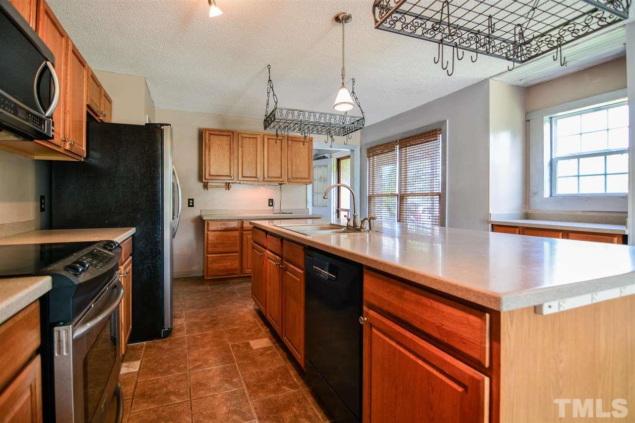 8235 Springhill Church Road Lucama, NC 27851 - Photo 23 of 30 a kitchen with stainless steel appliances granite countertop a sink stove and refrigerator