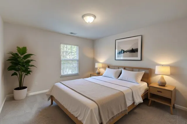 a bedroom with a bed and a potted plant