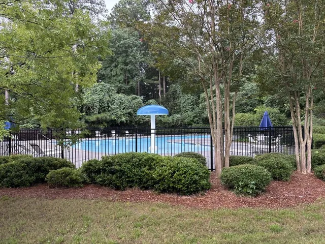 a view of a garden with a table and chair under an umbrella