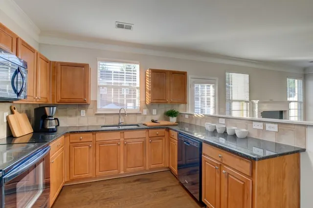 a kitchen with stainless steel appliances granite countertop a sink stove and cabinets