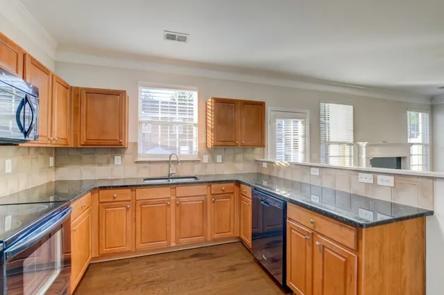 a kitchen with stainless steel appliances granite countertop a sink stove and cabinets