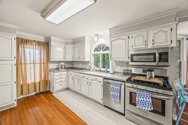 a kitchen with stainless steel appliances granite countertop a stove a sink and a refrigerator
