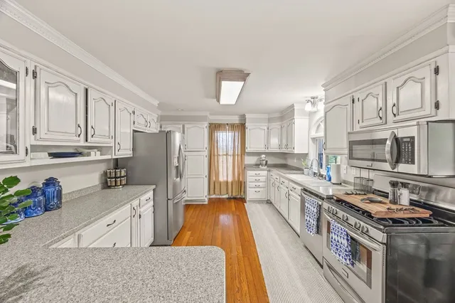 a large kitchen with stainless steel appliances granite countertop a stove a sink dishwasher and a refrigerator