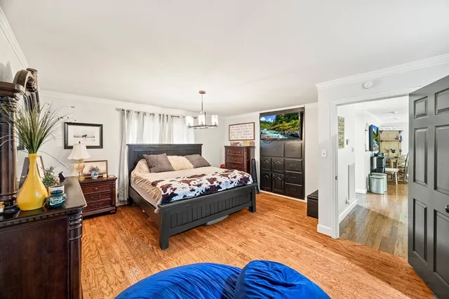 a bedroom with a bed and wooden floor