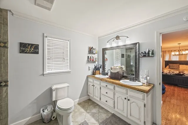 a bathroom with a granite countertop toilet sink and mirror