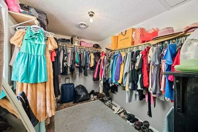 a view of walk in closet with clothes and shoes