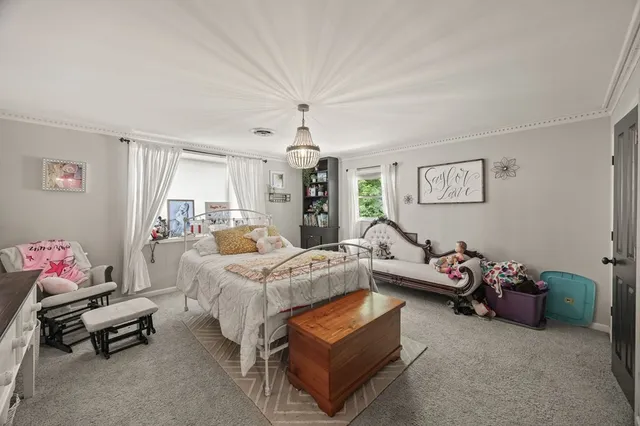 a spacious bedroom with furniture and a chandelier