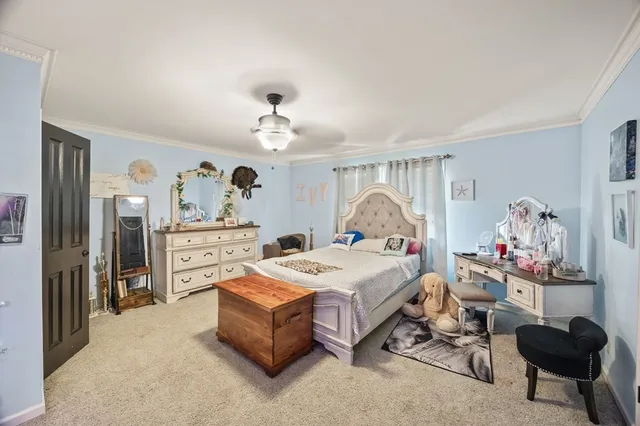 a spacious bedroom with a bed and a chandelier