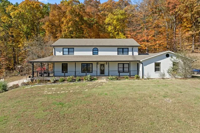 a front view of a house with a yard and balcony