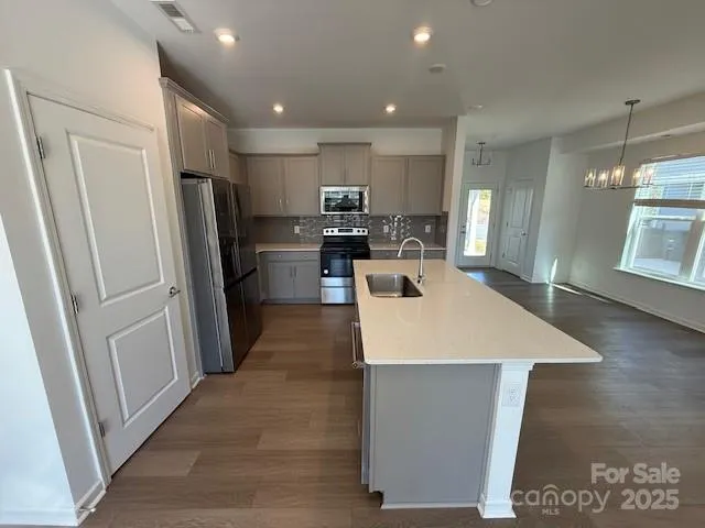 a kitchen with stainless steel appliances a refrigerator and microwave
