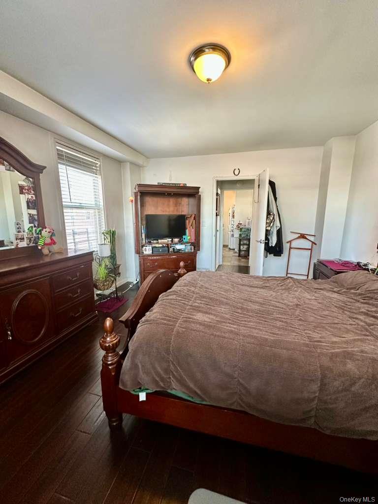 97-07 63rd Road, Unit 6H Queens, NY 11374 - Photo 13 of 17 a bedroom with a bed and wooden floor