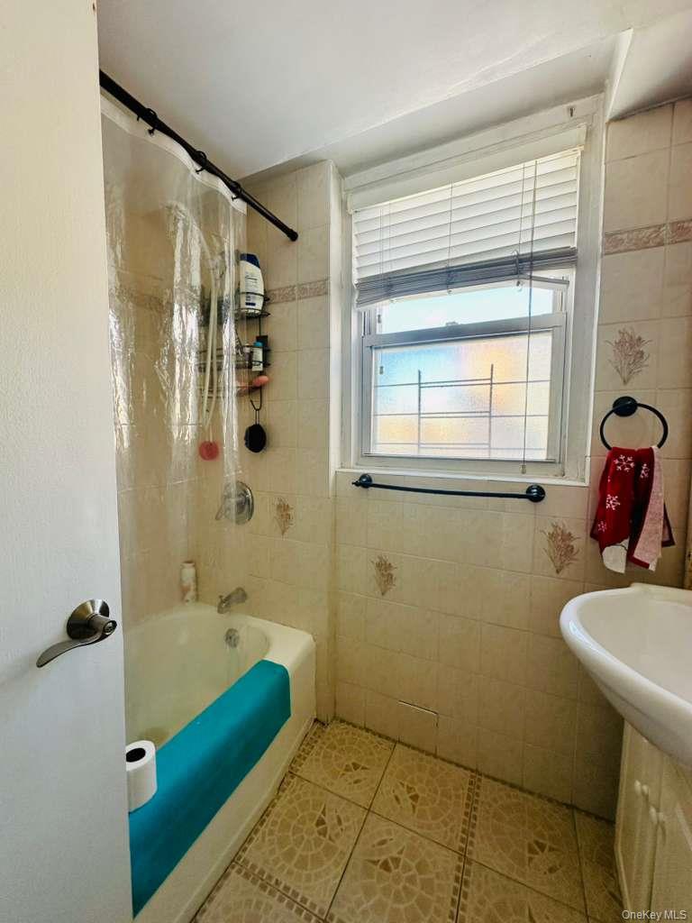 97-07 63rd Road, Unit 6H Queens, NY 11374 - Photo 17 of 17 a bathroom with a tub sink and mirror