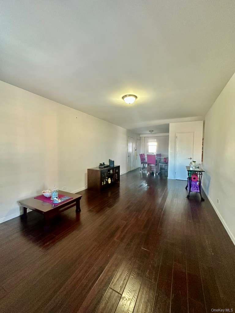 97-07 63rd Road, Unit 6H Queens, NY 11374 - Photo 4 of 17 a living room with furniture and a wooden floor