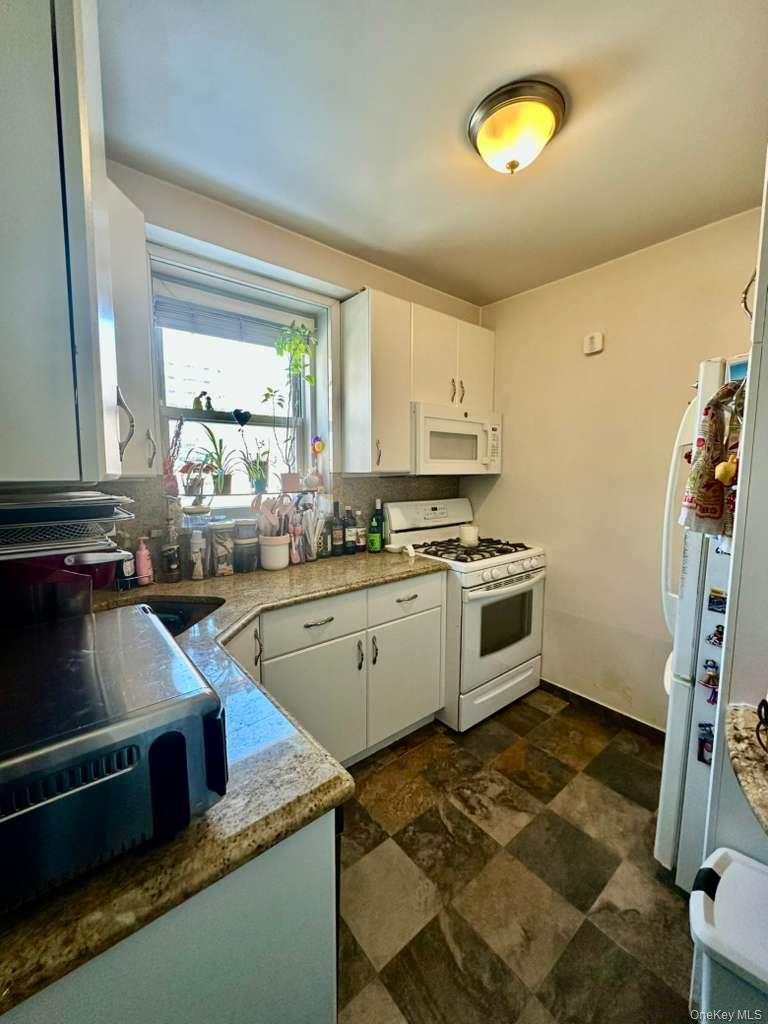 97-07 63rd Road, Unit 6H Queens, NY 11374 - Photo 6 of 17 a kitchen that has a sink and a stove