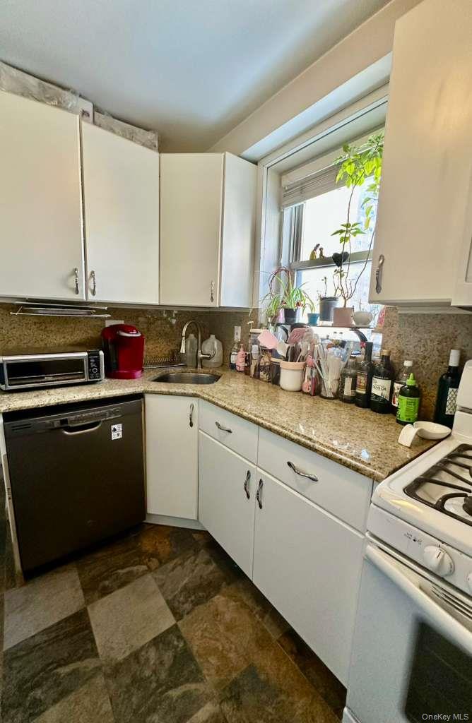 97-07 63rd Road, Unit 6H Queens, NY 11374 - Photo 8 of 17 a kitchen with a sink stove and cabinets