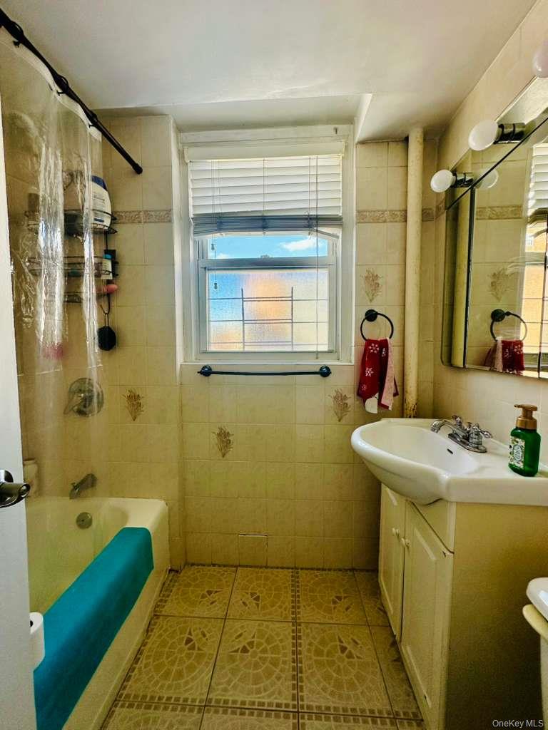 97-07 63rd Road, Unit 6H Queens, NY 11374 - Photo 9 of 17 a bathroom with a sink toilet shower and a mirror