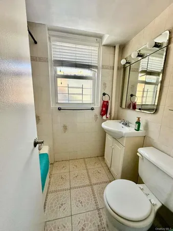 a bathroom with a toilet sink and mirror