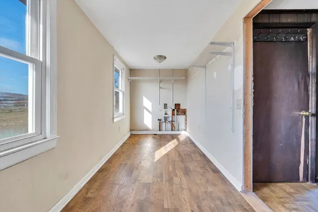 a view of a hallway with wooden floor and a living room