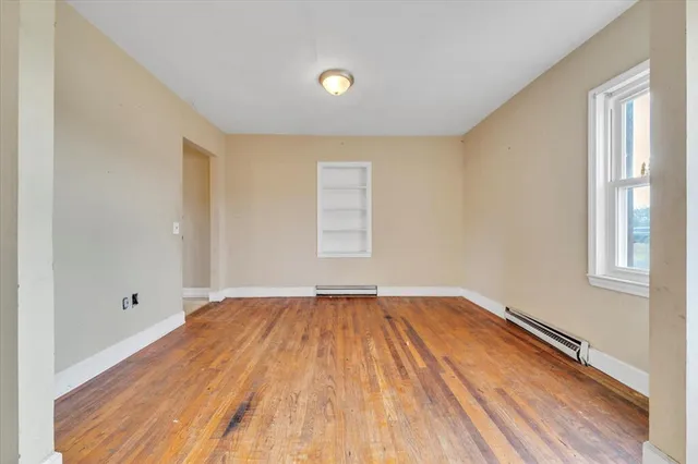 wooden floor in an empty room with a window