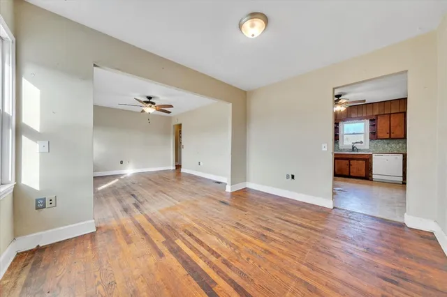 a view of a room with wooden floor and a kitchen