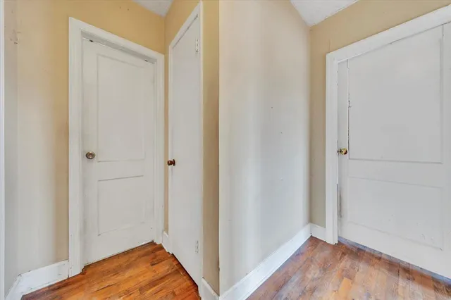 a view of room with hardwood floor and hallway