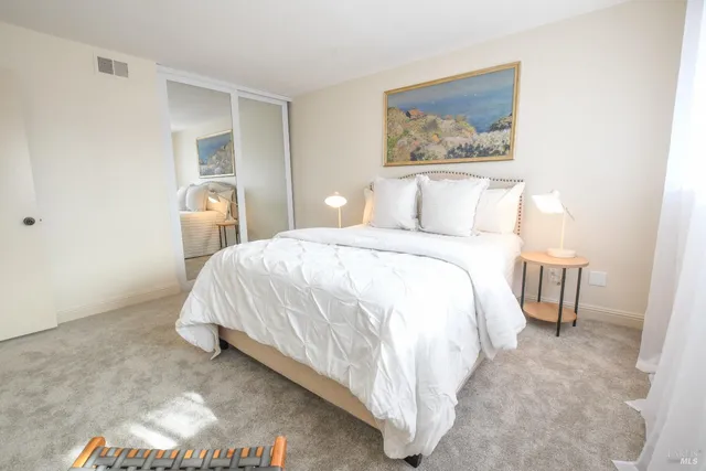 a bedroom with a bed and a painting on the wall