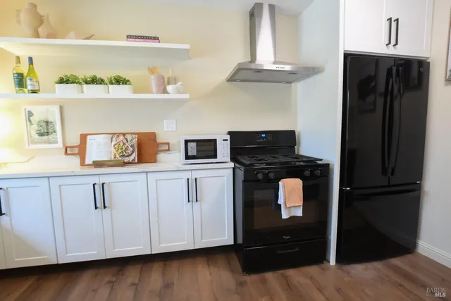 a kitchen with white cabinets and refrigerator