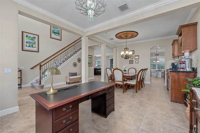 a dining room with furniture a chandelier and window