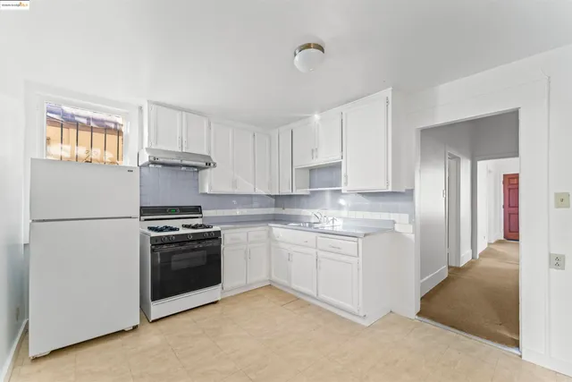 a kitchen with stainless steel appliances granite countertop a refrigerator and a stove top oven