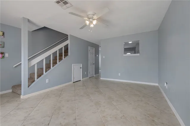 a view of an empty room with a ceiling fan