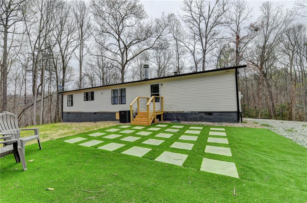 85 Betts Mine Road Dawsonville, GA 30534 - Photo 16 of 18 a backyard of a house with table and chairs