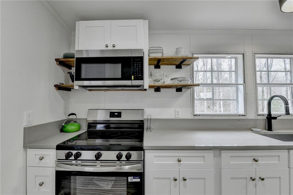 85 Betts Mine Road Dawsonville, GA 30534 - Photo 9 of 18 a kitchen with stainless steel appliances a stove a microwave and cabinets