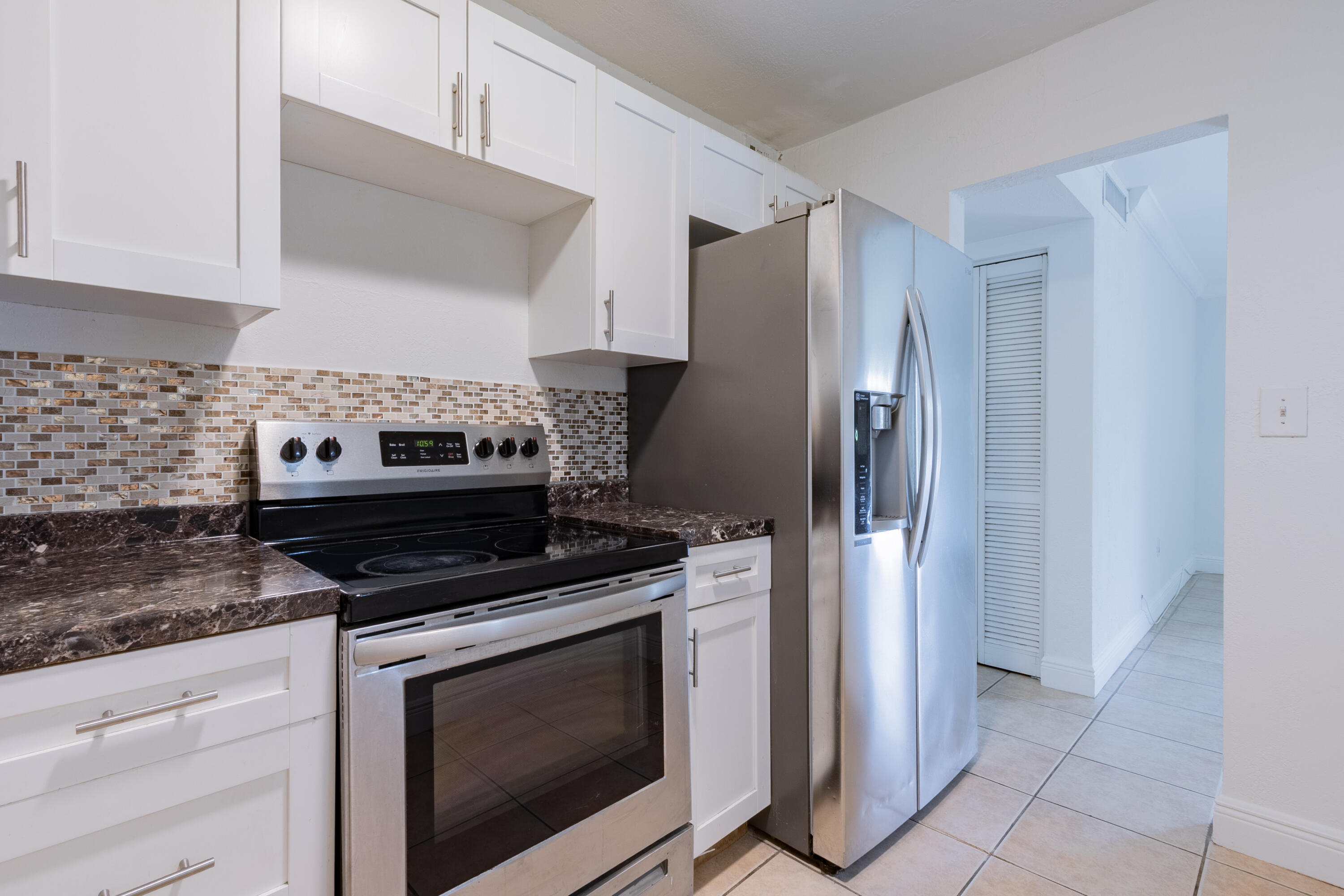9459 Southwest 76th Street, Unit R8 Miami, FL 33173 - Photo 2 of 21 a kitchen with stainless steel appliances granite countertop a stove and a refrigerator