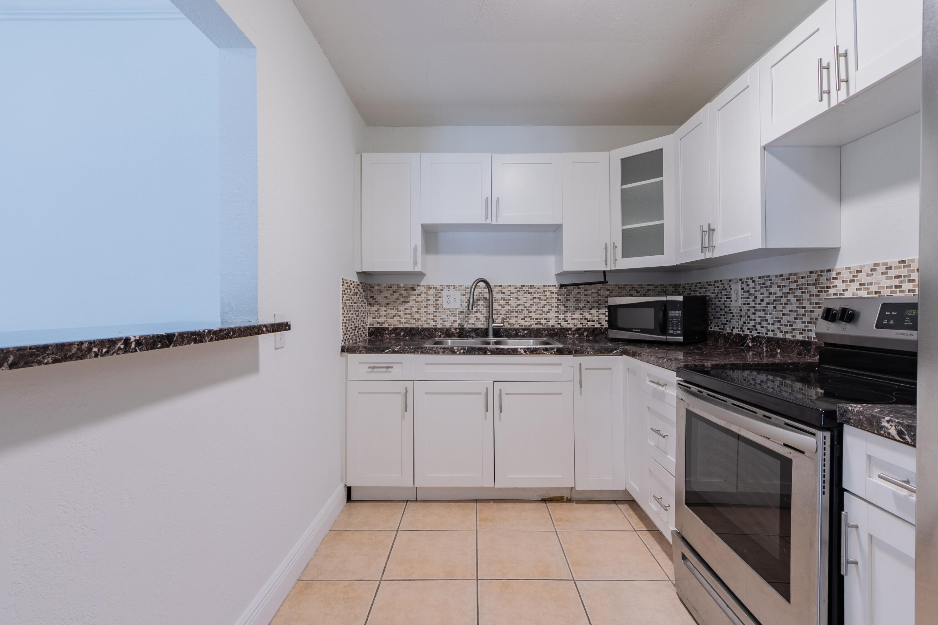 9459 Southwest 76th Street, Unit R8 Miami, FL 33173 - Photo 3 of 21 a kitchen with stainless steel appliances granite countertop a stove a sink and a refrigerator