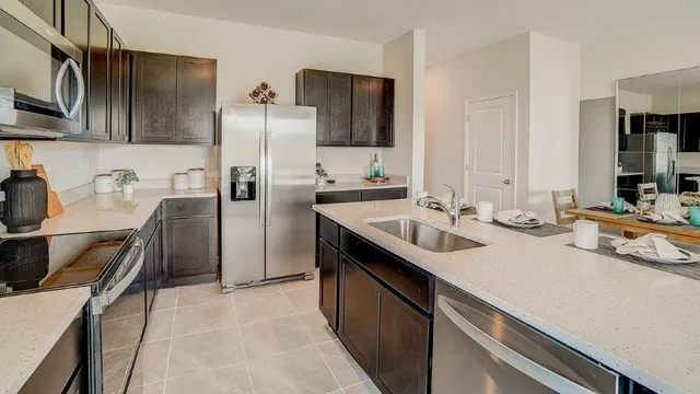 a kitchen with stainless steel appliances a sink stove and refrigerator