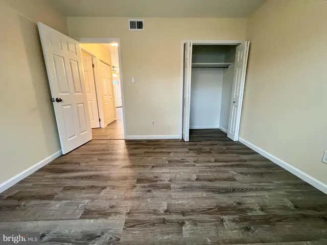 an empty room with wooden floor and entrance