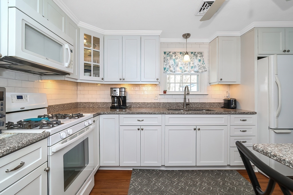 60 Security Street Barnstable, MA 02601 - Photo 8 of 32 a kitchen with granite countertop cabinets stainless steel appliances a sink and a window