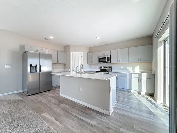 a kitchen with granite countertop white cabinets and black appliances
