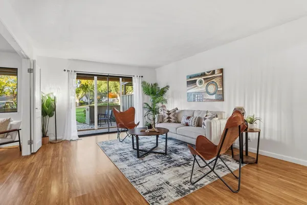 a living room with furniture and a wooden floor