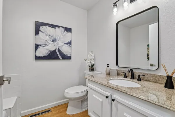 a bathroom with a granite countertop sink mirror and toilet