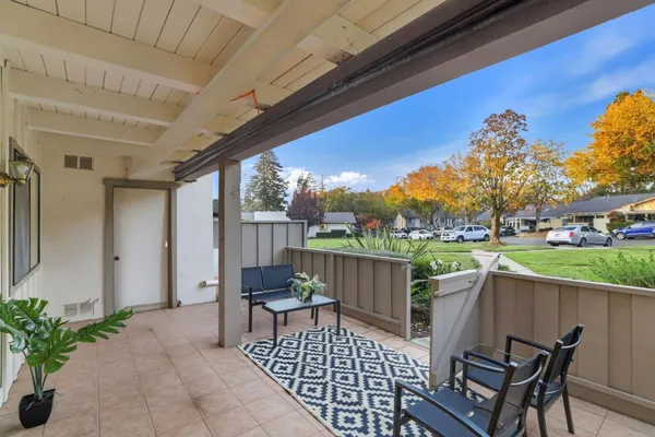 a view of a patio with couches table and chairs and potted plants