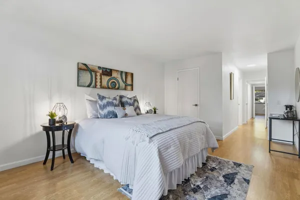 a bedroom with a bed and wooden floor
