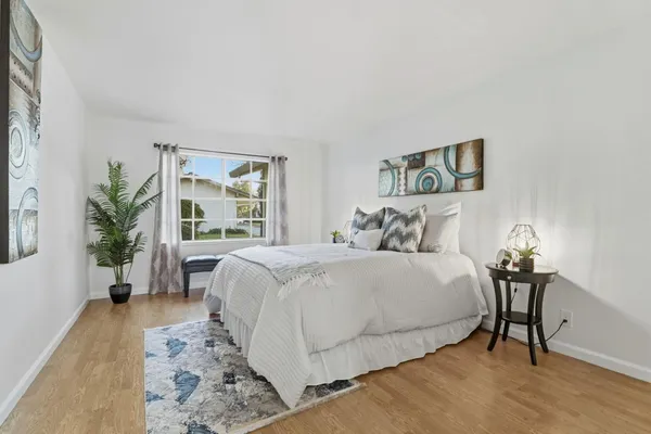 a bedroom with a large bed and a potted plant