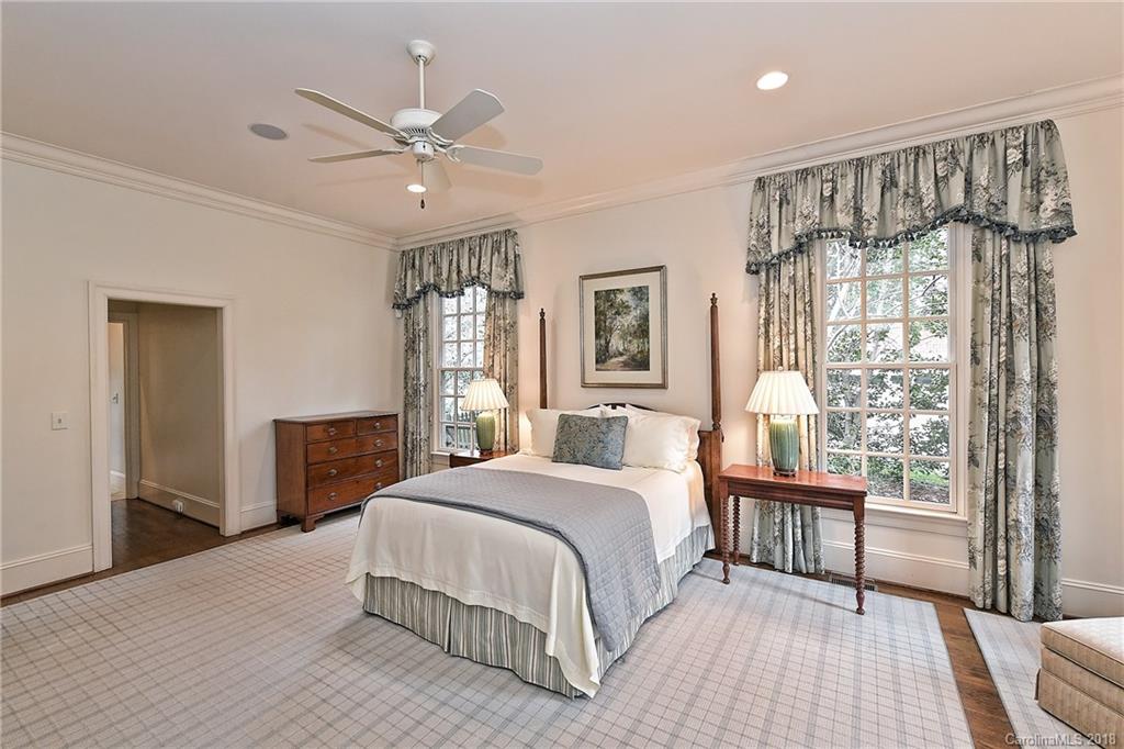 1912 Harris Road Charlotte, NC 28211 - Photo 14 of 36 a spacious bedroom with a large bed and a chandelier