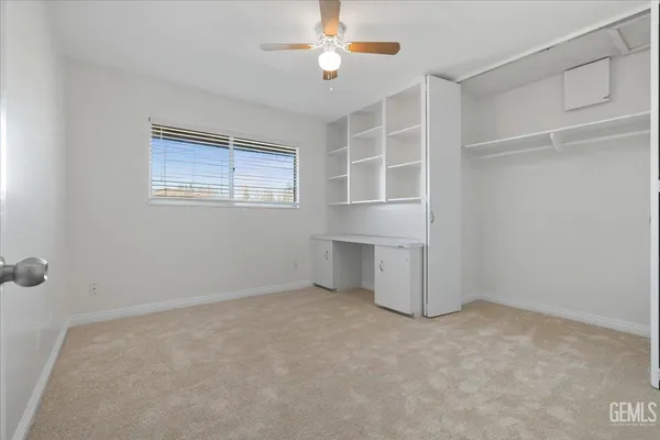 an empty room with closet and windows