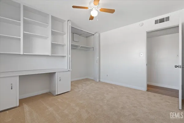 a view of an empty room with cabinet and a window