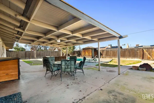 a view of a roof deck with table and chairs under an umbrella